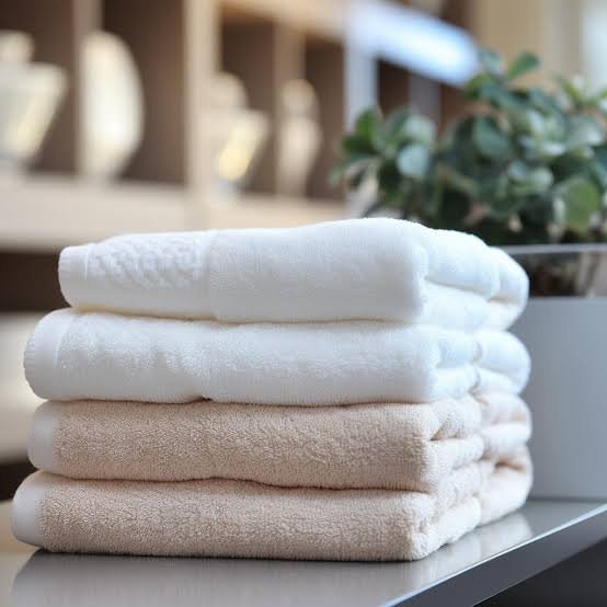 Freshly folded towels beside a plant