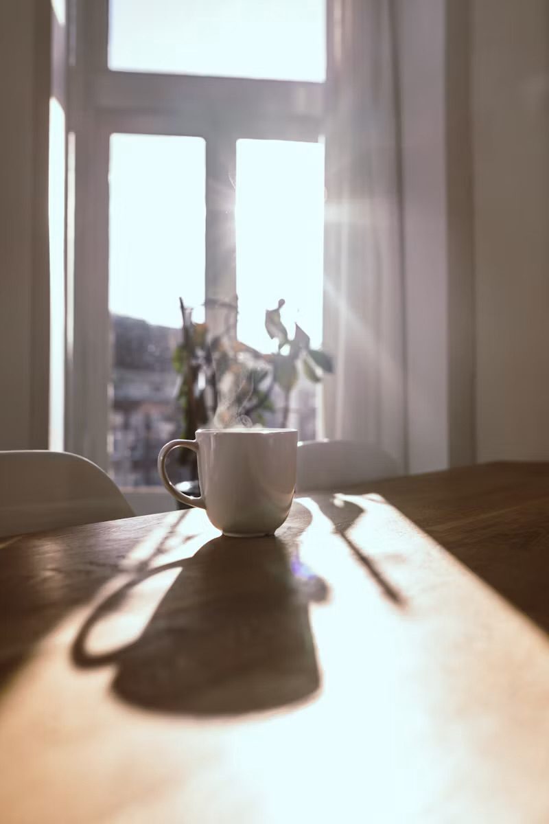 A cup of coffee on a sunlit table